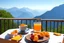 Placeholder: breakfast on a table on the terrace (orange juice, coffee in a cup, fruit, pastries), view of the mountains in the distance