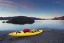 Placeholder: highly detailed glacial lake landscape, sunset, cinematic lighting, 4k, 8k, octane render, popular on 500px, pinterest, extremely detailed, ambient lighting, single frame, small fiberglass yellow solo symmetrical sea kayak on rock pebble beach in foreground, norway, iceland, fjord