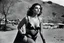 Placeholder: [photo by helmut newton in agent provocateur on the arena] Her complexion, after years spent training under the sun, bore the mark of a warrior who had weathered countless battles. Though her face spoke of hardship, there was also an air of grace and serenity that emanated from her every pore. Selene's physique was a testament to her dedication and discipline. Her muscular frame hinted at her physical prowess, yet her movements were fluid, as if she danced with the wind itself.