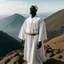 Placeholder: African man in white thobe, standing on top of mountain