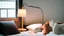 Placeholder: woman in bed with a bedside lamp and a cup of tea on the bedside table