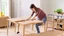 Placeholder: woman assembling the table she just received in the dining room