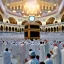 Placeholder: The scene in Mecca: People wearing white Ihram clothes, men without head coverings, women with veils, circumambulating around the Kaaba, and above them are transparent white spirits of children, men, and women with wings revolving around the Kaaba.