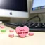 Placeholder: classic conversation hearts candy on a cubicle work desk table, one at the front reads "404 Love Not Found", background is a desk with a keyboard and a computer screen