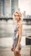 Placeholder: beautiful anorexic young woman, total shot, grey triathlon swimsuit, short blonde wavy bob hair, blurred city background