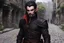 Placeholder: Dark elf male, goatee, rouge, black armor, leather armor, black hair, on a cobblestone road
