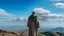 Placeholder: A Morisco general in an Arab dress stands with his back on the top of a mountain, in front of him is a flat land, and the sky is blue and full of clouds.