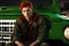 Placeholder: Young rugged looking male with red hair and green eyes sitting in a jeep close up photo realistic