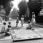 Placeholder: old fashioned a game of hopscotch on the street with girls discussing it next to it