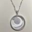 Placeholder: Clear polyester necklace with a silver pendant in the shape of a crescent moon