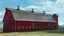 Placeholder: game art of a red barn with a blue sky and the sun and clouds with mountain in the background