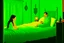 Placeholder: a knitted girl sitting on a bed and vomiting green lines, an exorcist priest standing next to her bed in a room in candlelight at night