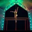 Placeholder: a picture of a gymnast lady show her performance on gymnastic parallel bar in a modern stage made of 3d geometric recursive structures and dynamic color lights