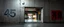 Placeholder: background of wall(wet textured concrete, gray, old, cracked, stained, 1 wall light) from underground parking, hong kong style, a large number "45" painted on left(old faded paint), at middle is an opening into an area with asian shops(poorly lit), cyberpunk, to the right of opening a faded painted rectangle