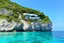 Placeholder: Impressive paradise islands, with elegant and luxurious futuristic homes on cliffs, vibrant and warm tones. Architecture, natural beauty, crystal clear waters, sun and lush vegetation