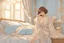 Placeholder: A beautiful woman with short brown hair in pastel blue lace robe is lying on a bed in a cute luxurious bedroom gold tapestry in the candlelight