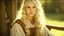 Placeholder: Sharp focus and high resolution closeup of a beautiful and slender caucasian 17 year old girl with long wavy platinum blonde hair. She is wearing a medieval peasant dress with a coset. She is seated at a spinning wheel gazing at the viewer. She has a cute nose, detailed full lips, skin texture. Natural lighting and low contrast. Face framed.