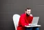 Placeholder: Man using laptop in red sweater