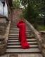 Placeholder: mysterious epic wizard walks up a tall stone stair case, lightning flashes in the sky, he is hurried, ragged red robes, carrying a staff with a crystal on the top