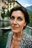 Placeholder: Act like a fashion photographer. Create a natural, realistic photograph of a small Italian town at Como Lake in late spring with a 40-year-old, looking younger than her age, beautiful, Italian woman in Monica Belluci style with short hair and black eyes. Use a fisheye lens and a Fuji T30 camera for mild light, warm, golden hour photos from a distance, elegant red dress,