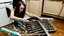 Placeholder: very confused young woman puts a few metal spoons into the household dryer