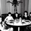 Placeholder: Creepy old photo of giger alien people sitting at dinner with weird children