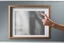 Placeholder: a hand giving an empty picture frame the finger