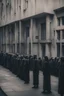 Placeholder: Dystopian image of a queue waiting outside a creepy building