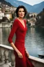 Placeholder: Act like a fashion photographer. Create a natural, not shiny, realistic photograph of a small Italian town at Como Lake in late winter with a 40-year-old, looking younger than her age, beautiful, Italian woman in Monica Belluci style with short hair and black eyes, elegant red dress,. Use a portrait lens and a Fuji T30 camera for mild light, cold, photo from a distance, low exposition