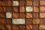 Placeholder: leather background covered with a grid of many rectangular weathered and faded canvas patches that are each stitched (brown) and nailed (brass) around the edges