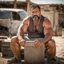 Placeholder: photography of a arab ugly burly serious wet sweaty, muscular chubby strong fat carpenter, shirtless, in broken dirty short pants, bulge, manly chest, very hairy, allover big goatee 46 years old, short hair, sitting with open legs on a little chair , on a construction site in the middle of a road, under the August sun, emotional eyes, , hyper-realistic, photorealistic , frontal view from the ground