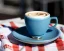 Placeholder: Cappuccino art microfoam in teal mug saucer Crawford plaid napkin Demitasse