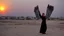 Placeholder: A Palestinian girls have wings wearing an palestinian dress in gaza during sunset in winter.