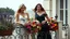 Placeholder: Two elegant women on a vintage balcony, a 25-year-old blonde in a flowing white dress and a 45-year-old brunette in a navy blue dress, overflowing pots of lavender and multi-colored petunias, relaxed poses leaning on the ornate railing, shiny hair moving in the wind, soft mid-afternoon light, intimate and contemplative atmosphere