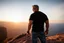 Placeholder: a brawny man with grey hair views sunset from a cliff