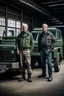 Placeholder: two haggard looking men working in a land rover warehouse