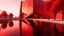 Placeholder: A futuristic architectural structure composed of massive angular red stone volumes emerging from a shallow reflective water surface. The building features sharp, geometric forms and inclined walls, creating a sculptural and dynamic presence. Warm sunlight casts soft shadows on the textured red facade, while silhouettes of small human figures offer a sense of scale. Minimalist landscape with leafless trees and a calm, golden-hour sky.
