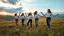 Placeholder: a group of Turkish young ladies in sports pants and blouse are dancing in high grassy hills,wild flowers ,cloudy sun set sky