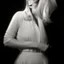 Placeholder: Mujer rubia iluminada, retrato medio cuerpo, iluminada potentemente desde el lado derecho, blanco y negro vaporoso, peinado a lo Verónica Lake al estilo del fotógrafo Hugo Alonso