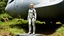 Placeholder: A photorealistic image of an adventurous, slender, 50-year-old woman from the future, dressed in a fitted, full-body spacesuit, stands proudly beside her huge, wide, sleek, wingless cargo starship. Her uncombed, blond hair has bangs. She is standing on a metal box in a jungle clearing.