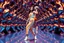 Placeholder: beautiful lady with todays modern clothing and sport shoes, in surreal stage made of 3d fractal random size recursive objects with helical strip colors in clothing similar to environment full body dancing to camera,animating background metallic random color and size recursive objects