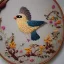 Placeholder: exquisite whimsical birds in embroidery hoop, intricate, highly detailed, linen and wood backdrop