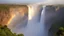 Placeholder: Victoria Falls in Zambia, brilliant waterwall casting a heavy mist at the bottom, brilliant rainbow, kaleidoscope of colours, award winning nature photography for a travel magazine, dramatic