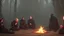 Placeholder: Black robed monks sitting around a fire in the forest