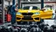 Placeholder: A car repair shop where two people in work clothes are repairing a yellow BMW M6 series with an eye-catching theme in a sophisticated and special repair shop where a collection of car engine parts is arranged on the floor at the bottom of the image.