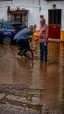 Placeholder: A natural phenomenon, floods in an Alentejo village with two politicians on the scene. Mario Soares and Cavaco Silva- Shot on Canon EOS R5, 50mm lens, depth of field, shutter speed 1/1000, f/2.8, white balance, 6000k. High resolution, realistic details, HDR efects, film grain, 4K. –ar 9:16 –s 700 –q 5