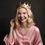 Placeholder: A beautiful woman with beautiful blond hair, happy, wearing a modest velvet pajama, her hands are pink, and a crown is on her head.