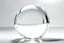 Placeholder: Eine leuchtend weiße durchsichtige große spiegelnde Glaskugel