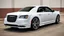 Placeholder: "A sleek white Chrysler 300 with custom LED headlights and smoked taillights, featuring a mesh grille in chrome with black accents. It has a subtle carbon fiber ducktail spoiler, sitting on 22” multi-spoke concave wheels in brushed silver. The suspension is lowered slightly for a more aggressive stance, while the body is painted a glossy black. The interior boasts custom leather upholstery with ambient lighting for a refined, luxurious look."