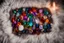 Placeholder: top view of lot of coloured gemstones on fluffy blanket in candlelight